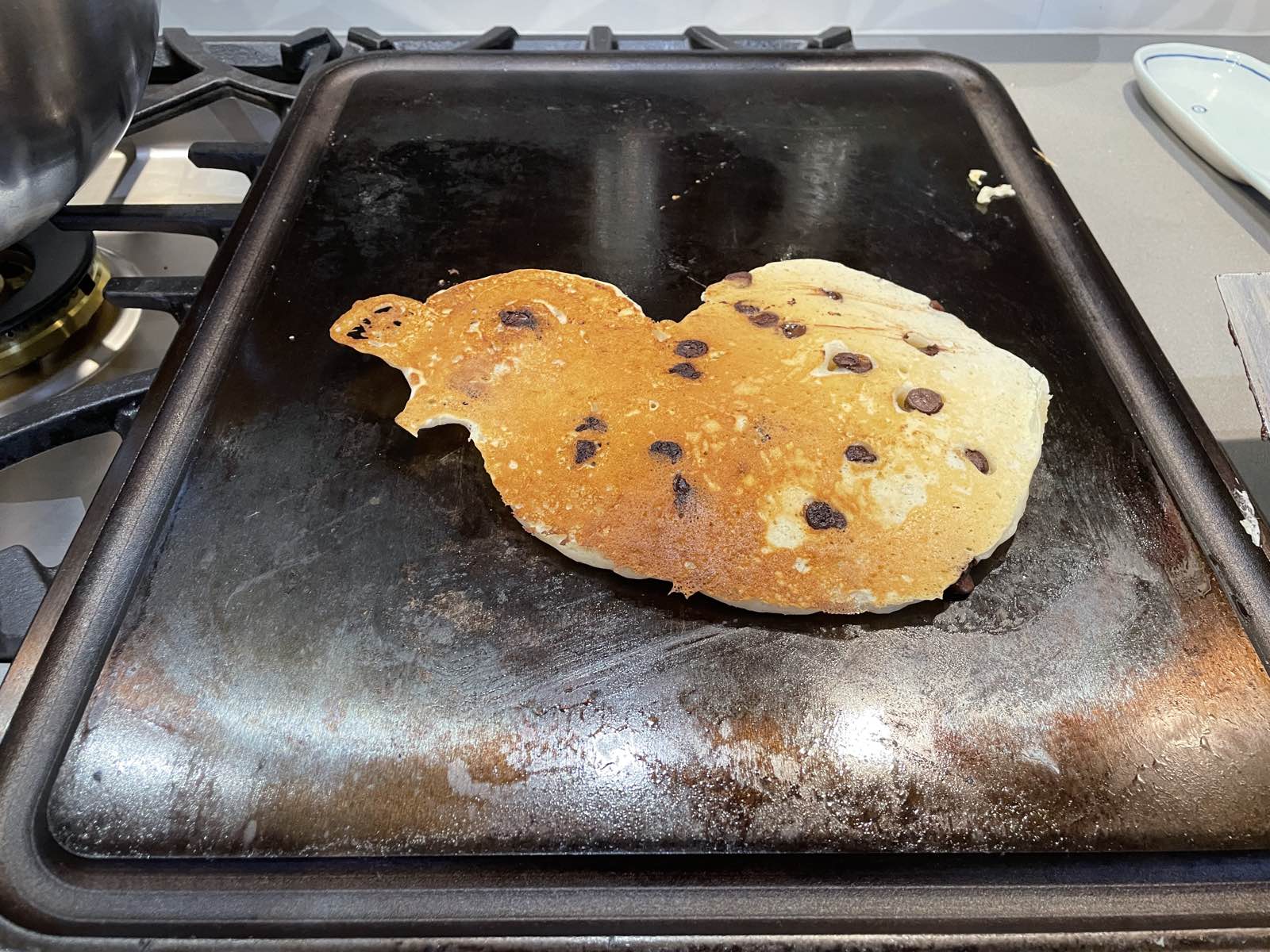 a really messed up pancake, flipped over on a griddle