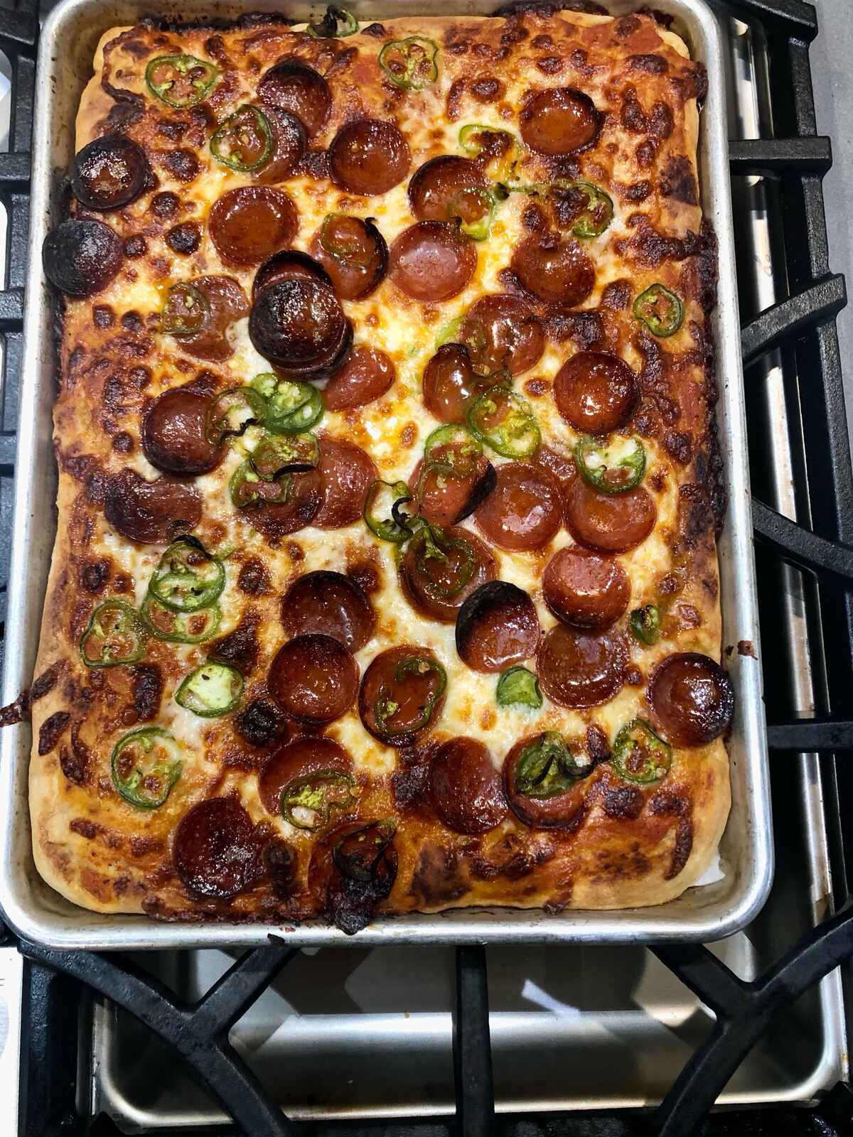 A rectangular pepperoni and jalapeño pizza