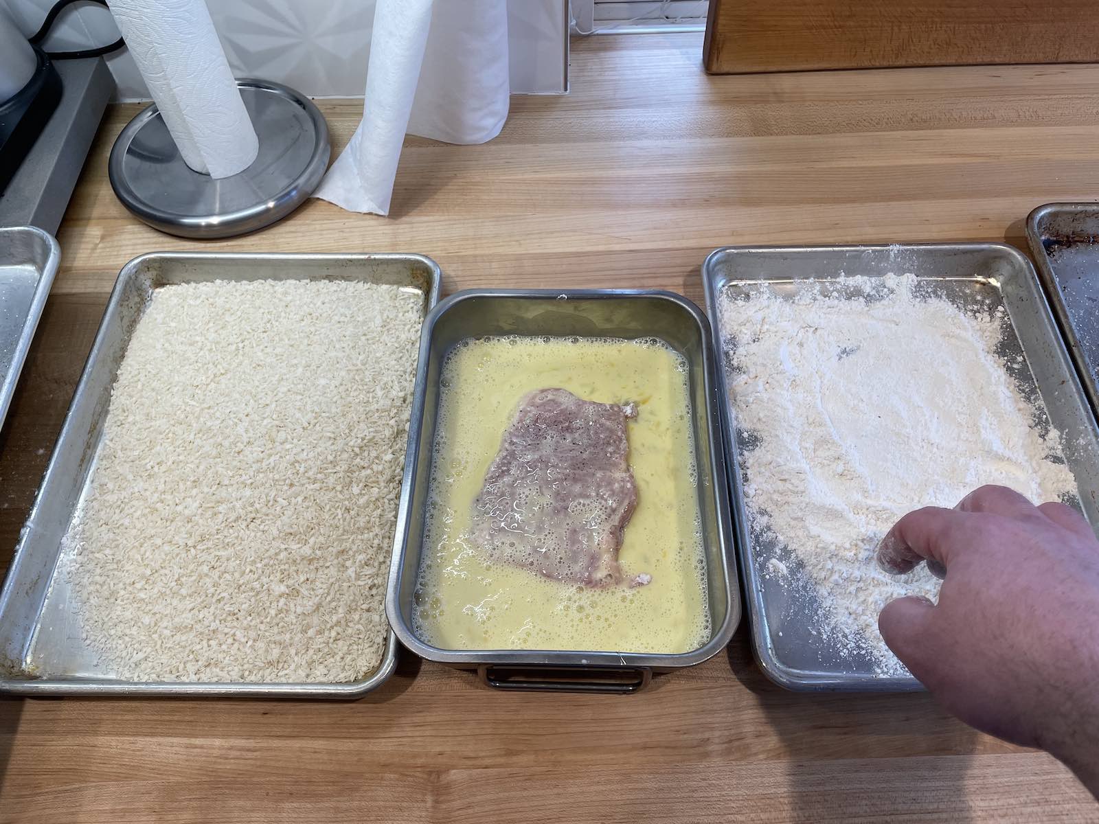 A breading station with three bays: flour, egg wash, breadcrumbs